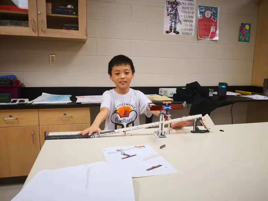 Young CK at a LEGO engineering club table during an after-school meeting